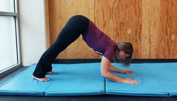 Practicing an inverted press on a floor mat